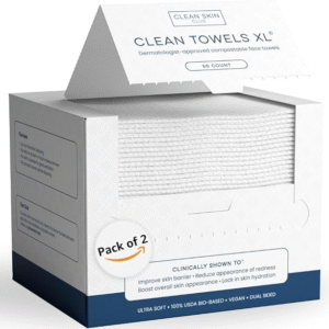 A stack of clean, white Clean Skin Club biobased face towels on a bathroom counter with green plants.