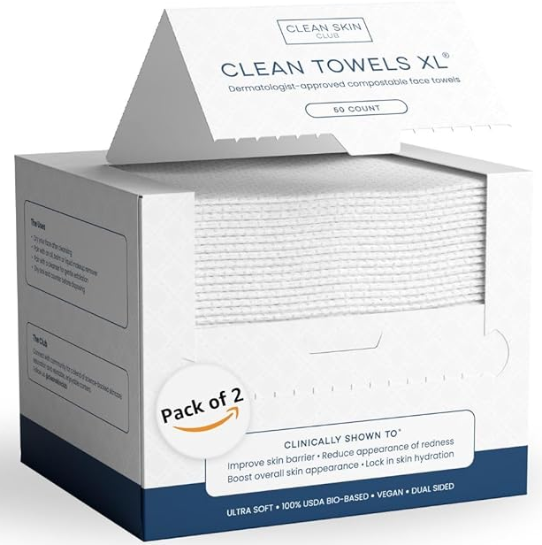 A stack of clean, white Clean Skin Club biobased face towels on a bathroom counter with green plants.