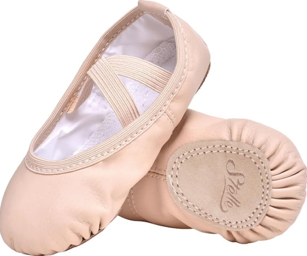 A young girl in a pink Stelle ballet shoe practicing a dance pose on a studio floor.