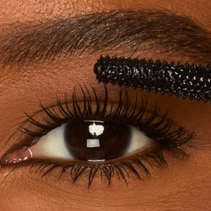 A close-up of Tarte's Tartelette XL Tubing Mascara wand coating lashes for a smudge-proof, voluminous look.