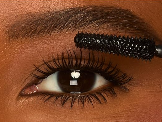 A close-up of Tarte's Tartelette XL Tubing Mascara wand coating lashes for a smudge-proof, voluminous look.